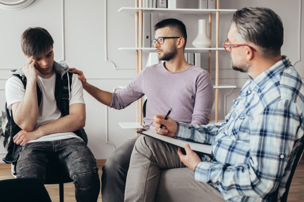 Friend comforting his peer while at the therapist